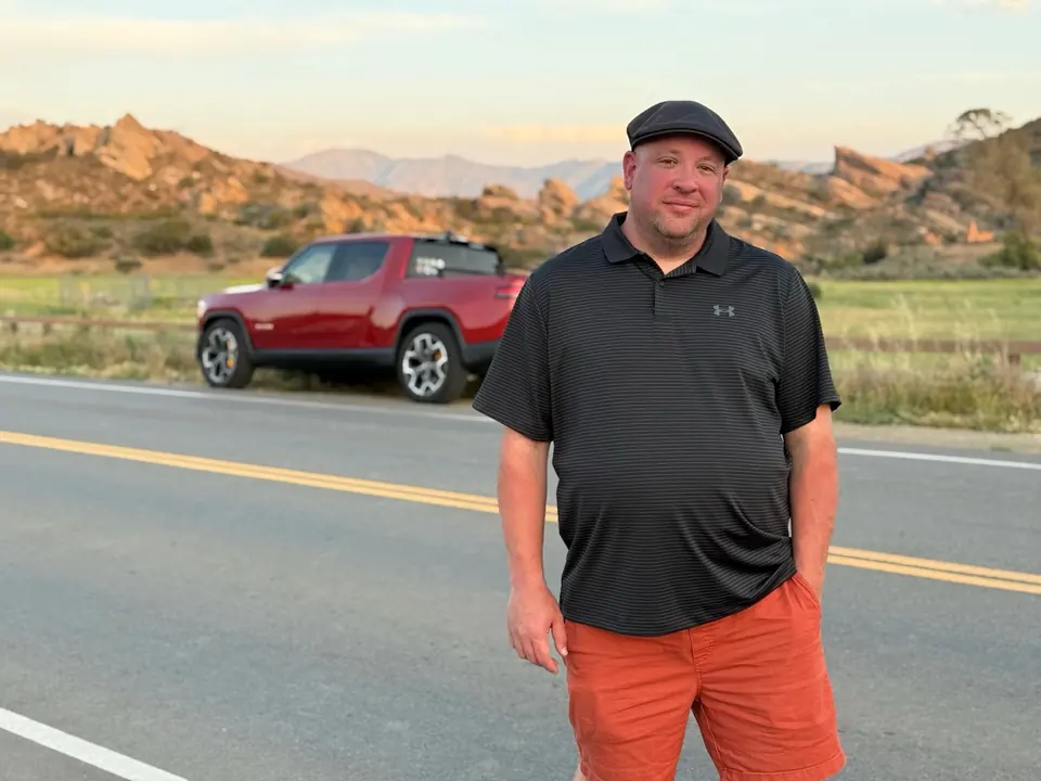 Zak Winnick standing near his R1T at Vasquez Rocks
